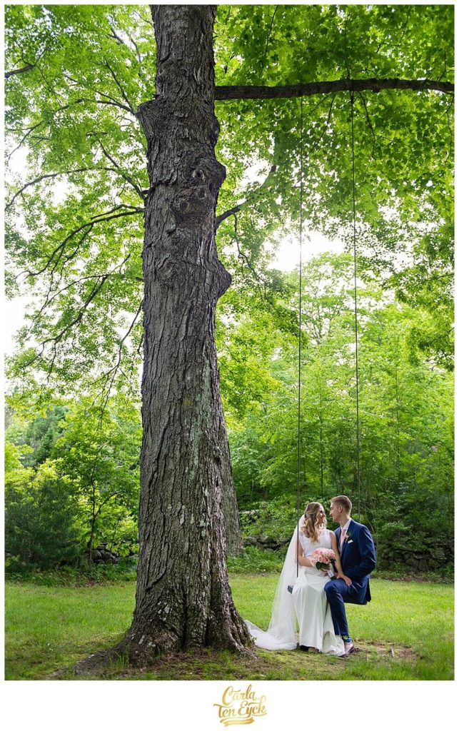 Newly marries couple snuggles on a swing on a backlit tree on Wright's Mill Farm in Canterbury CT