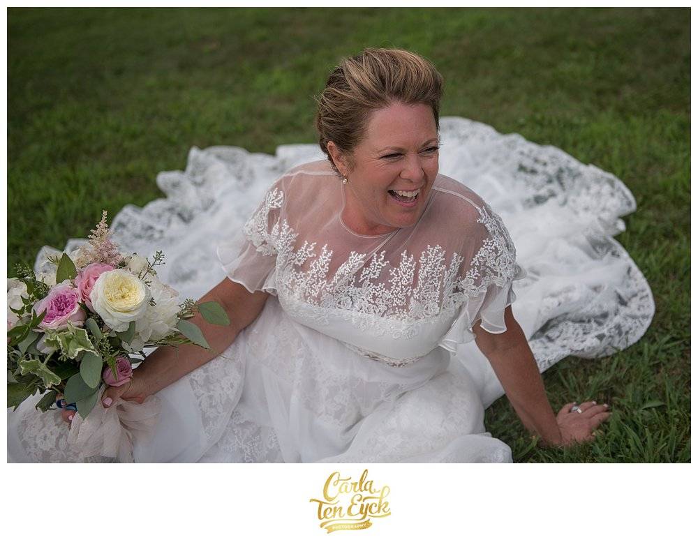 Bride laughs in her Rivini wedding dress while holding her garden rose wedding bouquet Harkness Park, Waterford CT