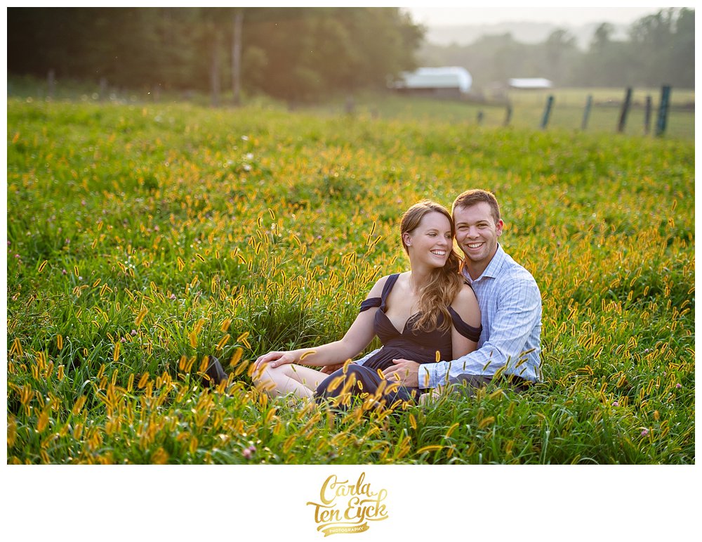 Happy couple in a field at sunset at their engagement session at Heritage Homestead in Northford CT
