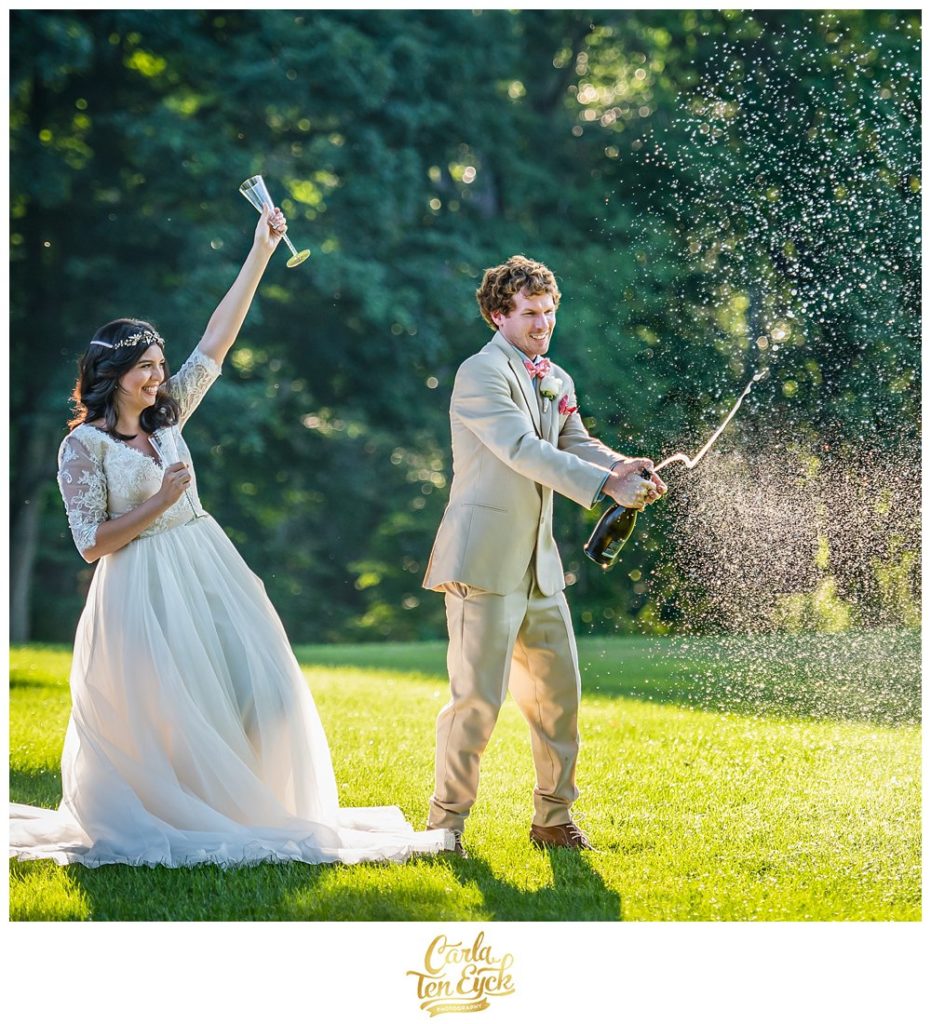 Bride and groom pop champagne at their wedding at Smith Farm Gardens in East Haddam CT