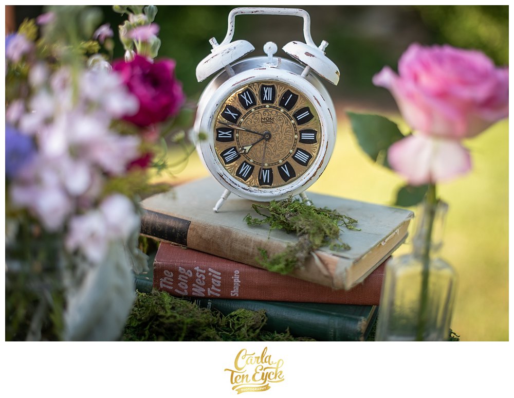 Vintage clock on old books at Alice in Wonderland themed shoot at Smith Farm Garden in East Haddam CT