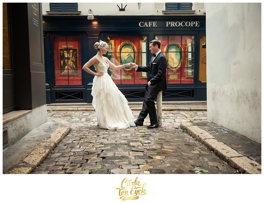 Bride and groom hold hands in a cobblestone alley in Paris, France