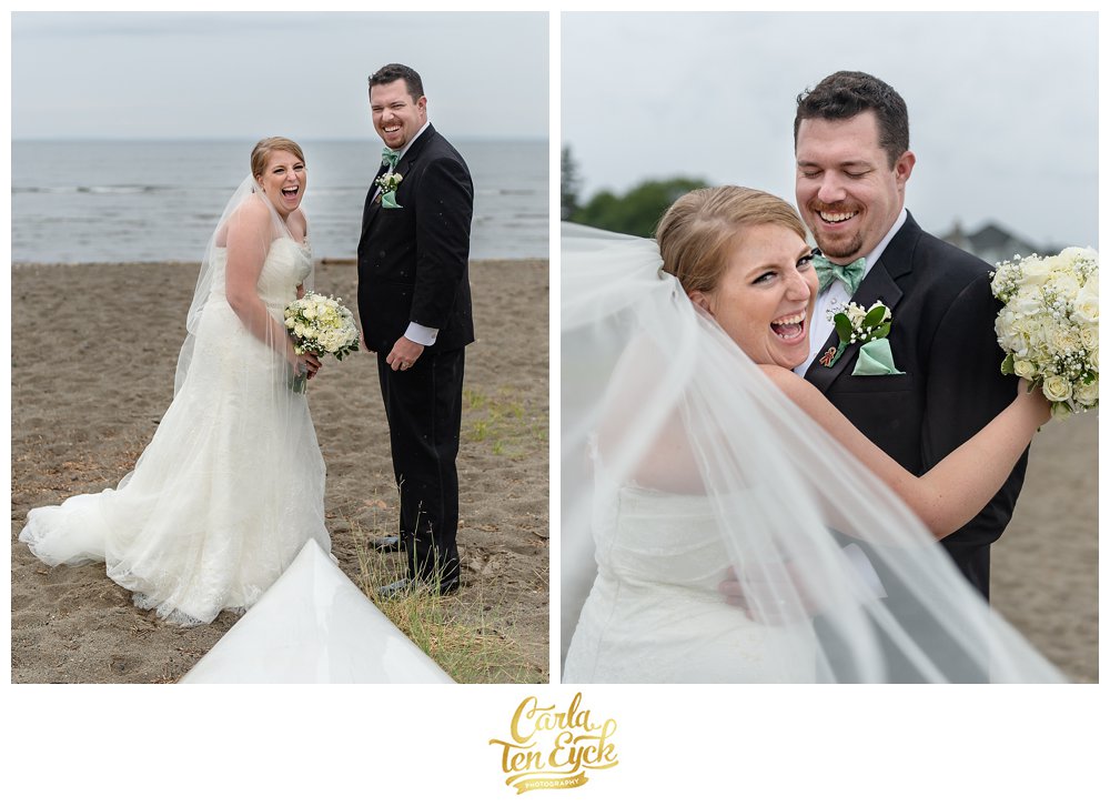 Happy couple on the beach in the rain in her Augusta Jones wedding gown in Lordship CT