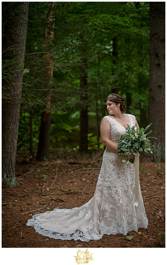 Bride in the woods wearing a lace wedding gown with a eucalyptus wedding bouquet in Glastonbury CT