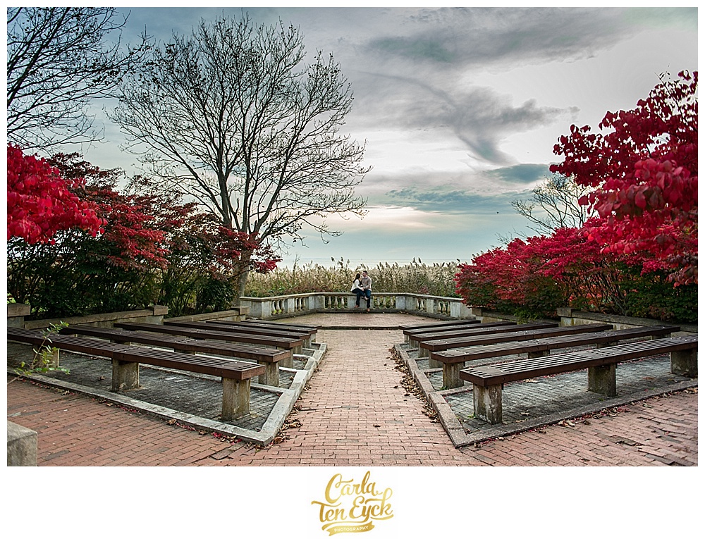 Couple sits in the amphitheater at their engagement session at Harkness Memorial Park in Waterford CT