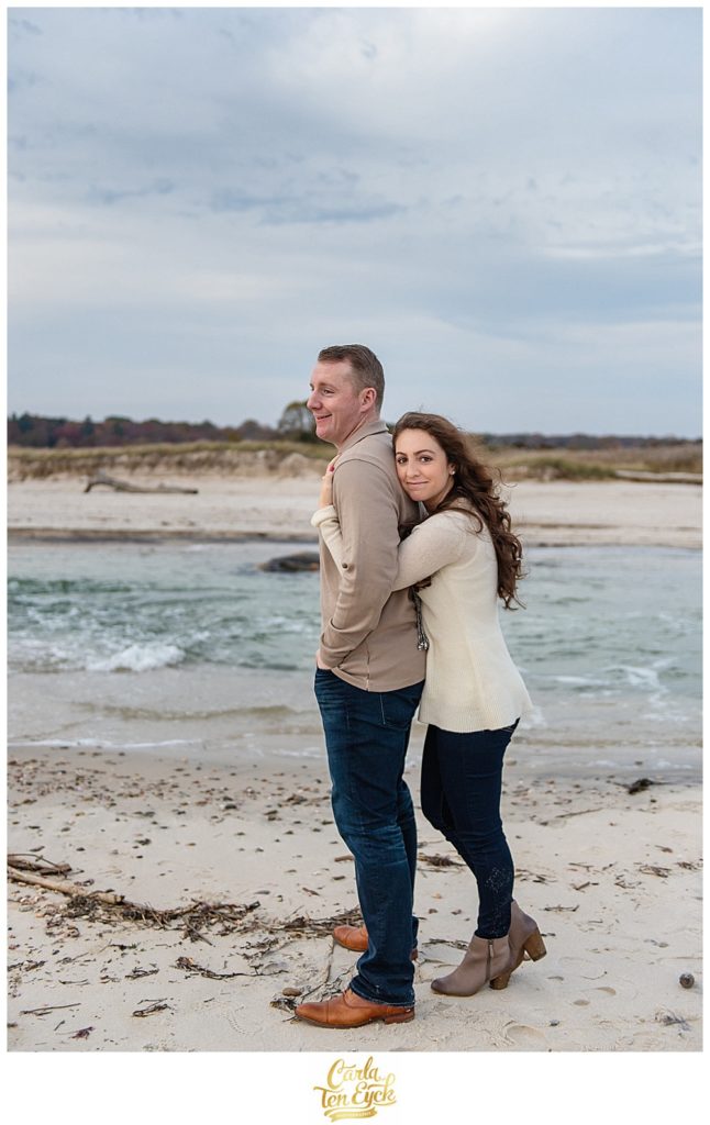 Couple cuddles on the beach at Harkness Memorial Park in Waterford CT
