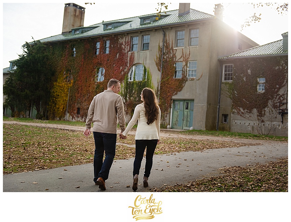 A couple walks during their autumn engagement session at Harkness Park in Waterford CT