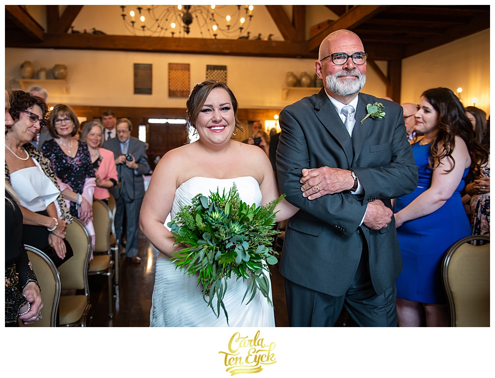 A joyful and emotional bride walks down the aisle with her father at her wedding at the Publick House in Sturbridge MA