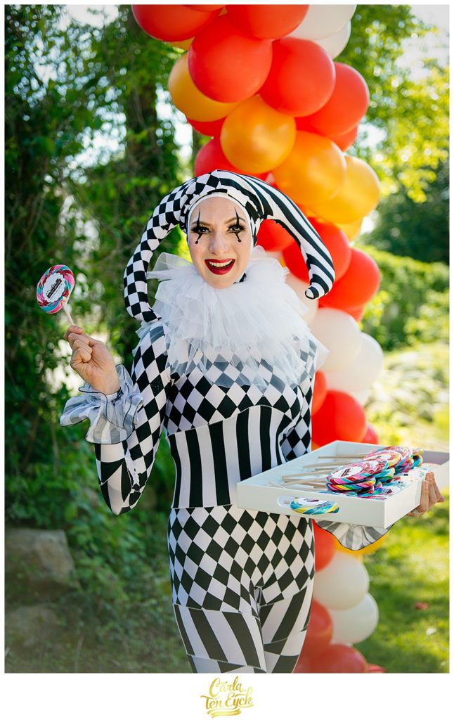 Jester greets guests with lollipops at carnival themed graduation party in Niantic CT