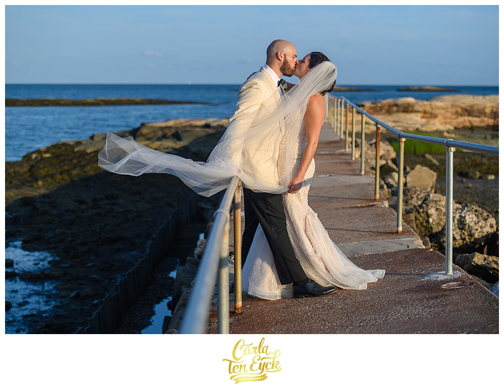 Bride and groom kiss on the rocks at their wedding at The Owenego Inn in Branford CT