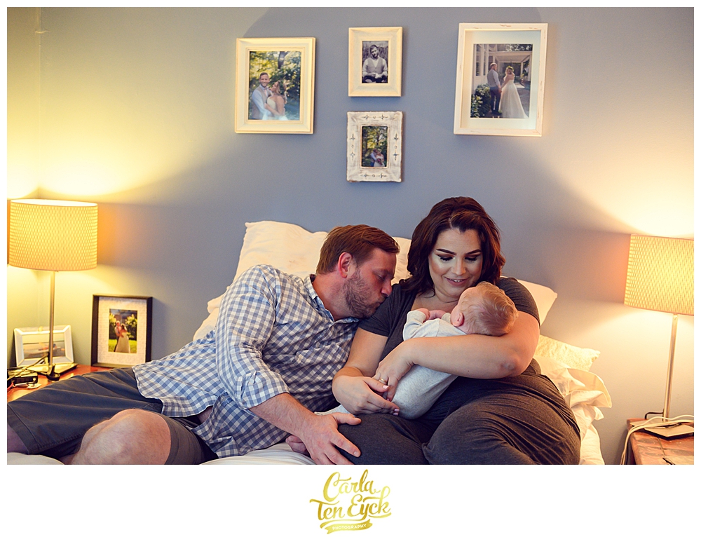 New parents snuggle their newborn son in their home in Old Lyme CT during their family session with photographer Carla Ten Eyck