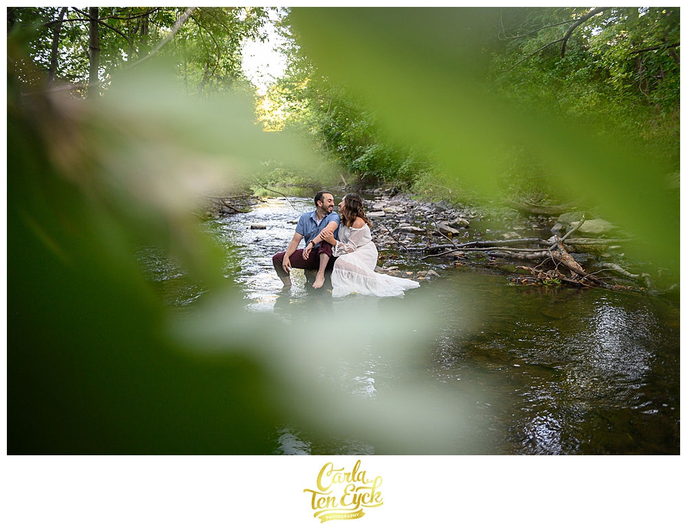 A couple embraces in the Hog River in Hartford CT during their engagement session