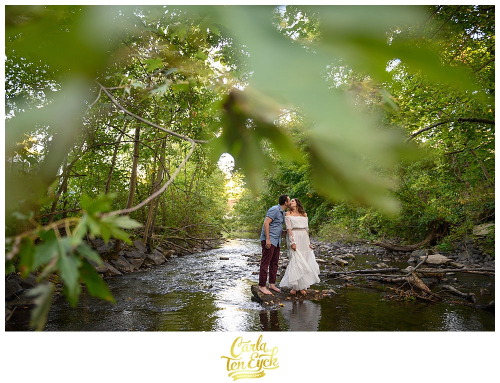 A couple kisses during their engagement session in the Park / Hog River in Hartford CT