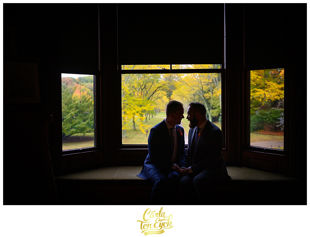 Two grooms snuggle at their wedding at the Eustis Estate in Milton MA