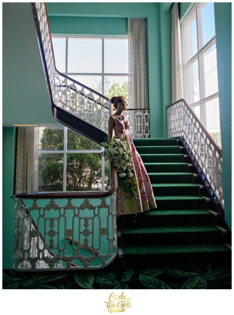 A bride poses on the colorful stairway at The Greenbrier in West Virginia