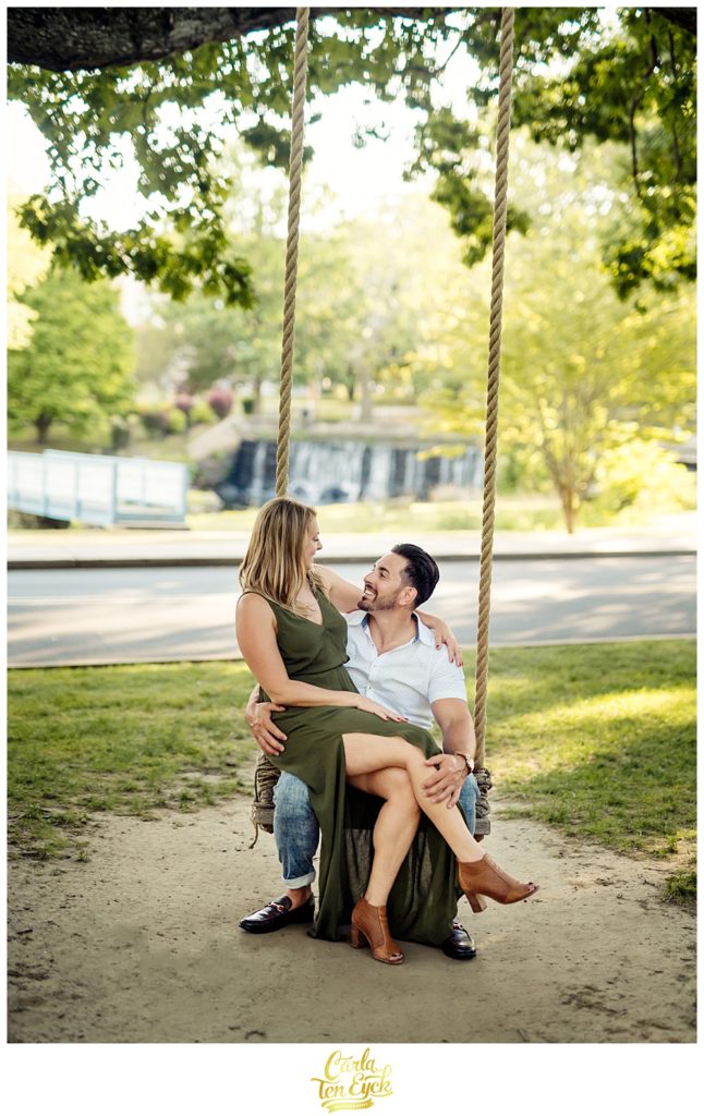 A couple smiles on a swing during their Milford CT engagement session