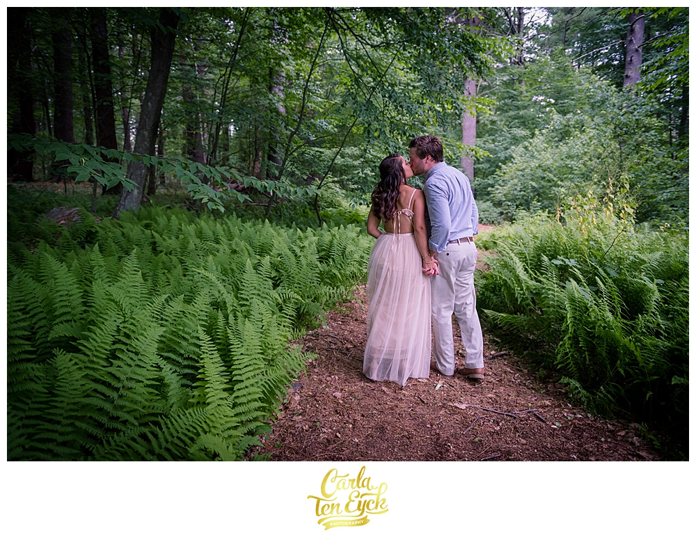 A couple kisses in the ferns during their micro wedding during covid 19