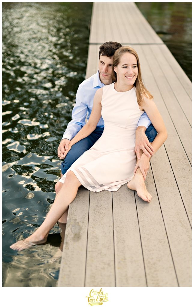 A couple relaxes on the dock on Lake Waramaug CT during their engagement session
