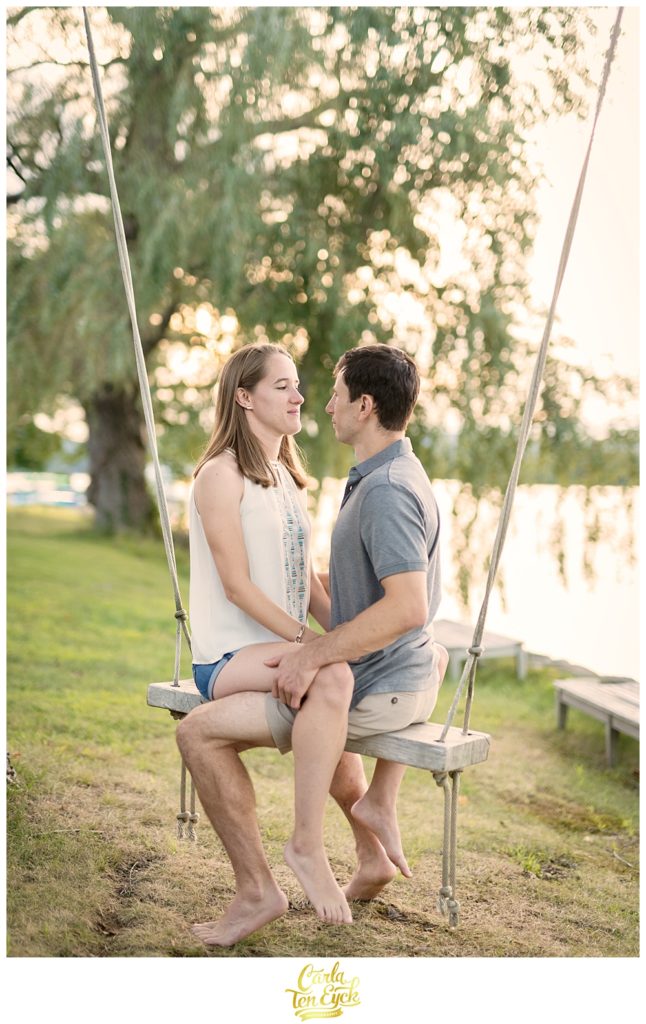 A couple on a swing on Lake Waramaug CT during their engagement session