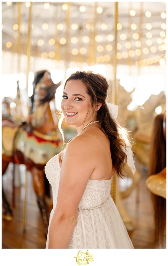 A bride poses for photos at their wedding at Lighthouse Point Park in New Haven CT in the carousel