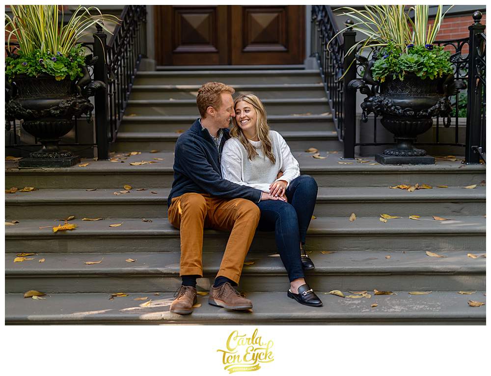 Couple snuggles on a stoop during their Boston engagement session.