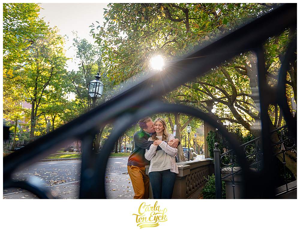 A couple snuggles on a stoop during their Boston engagement session