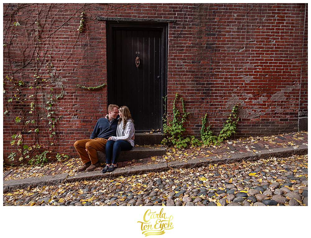 A couple snuggles on Acorn Street during their Boston Engagement session.