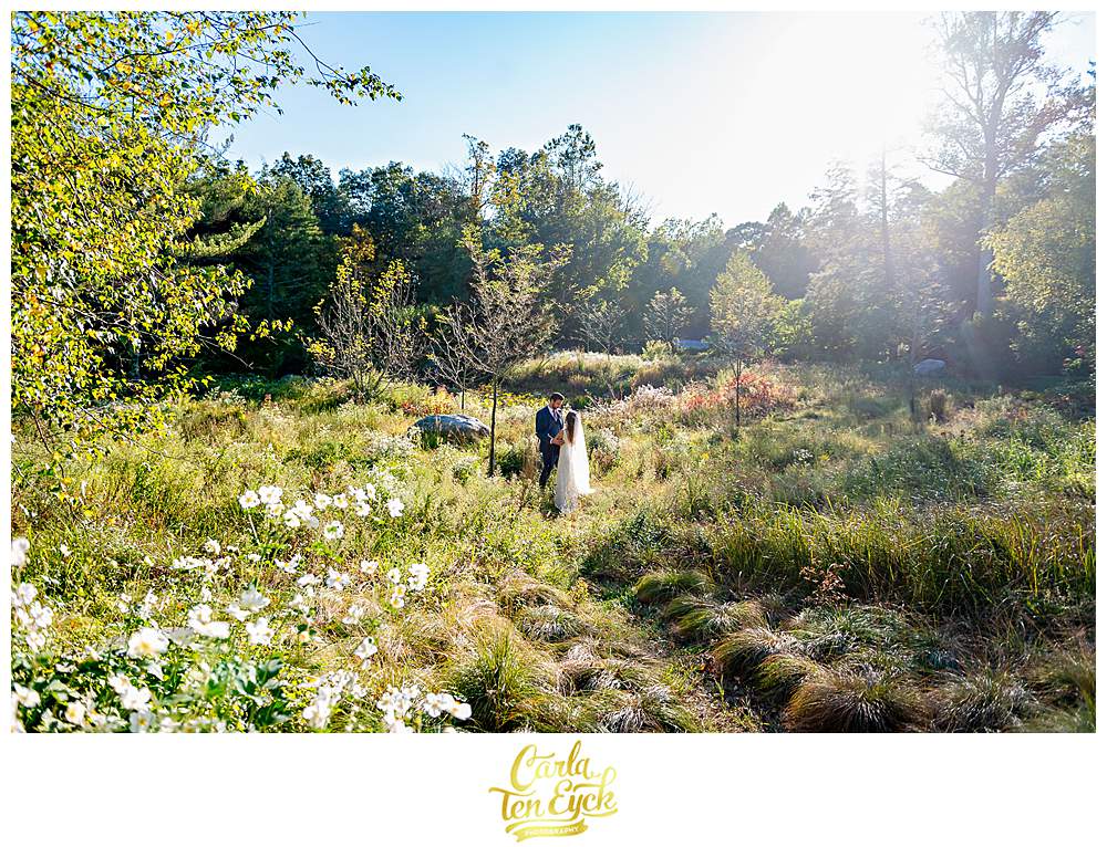 A bride and groom walk in a field during their intimate wedding at The Chatfield Hollow Inn in Killingworth CT