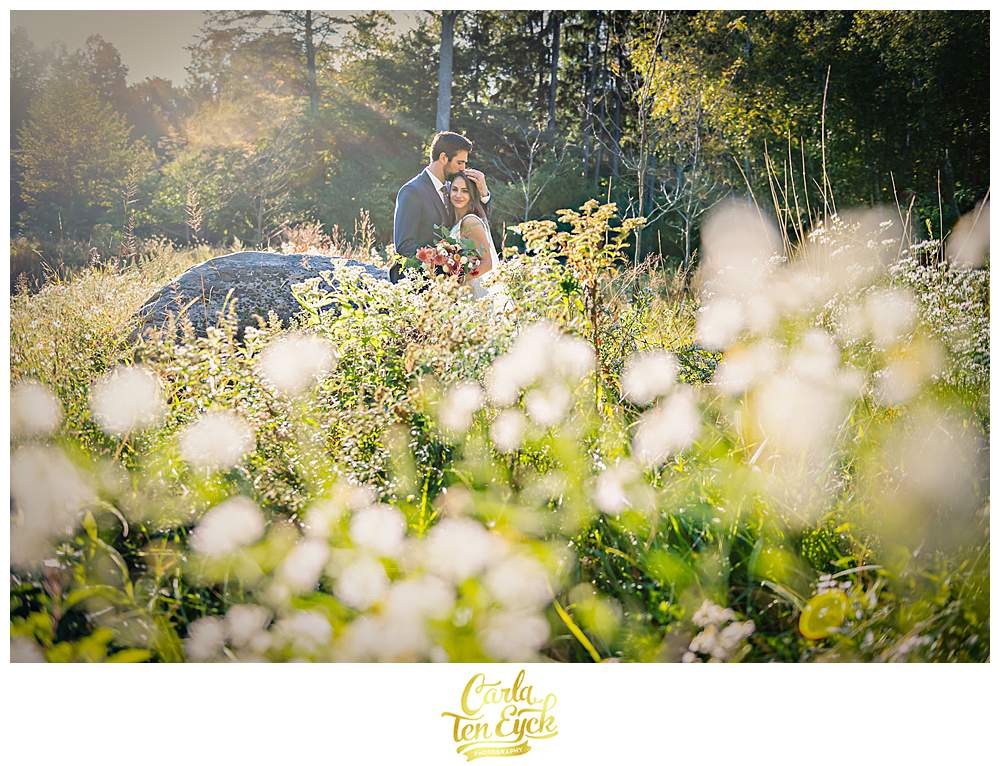 A bride and groom embrace in a field during their intimate wedding at The Chatfield Hollow Inn in Killingworth CT