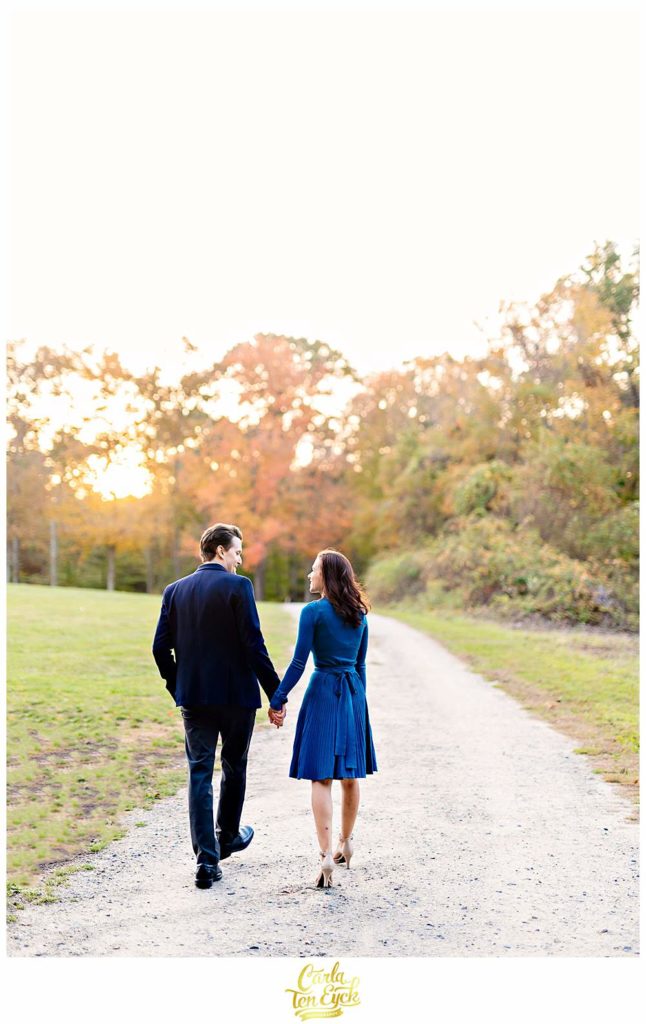 A couple walks a path during their engagement session at Smith Farm Gardens in East Haddam CT