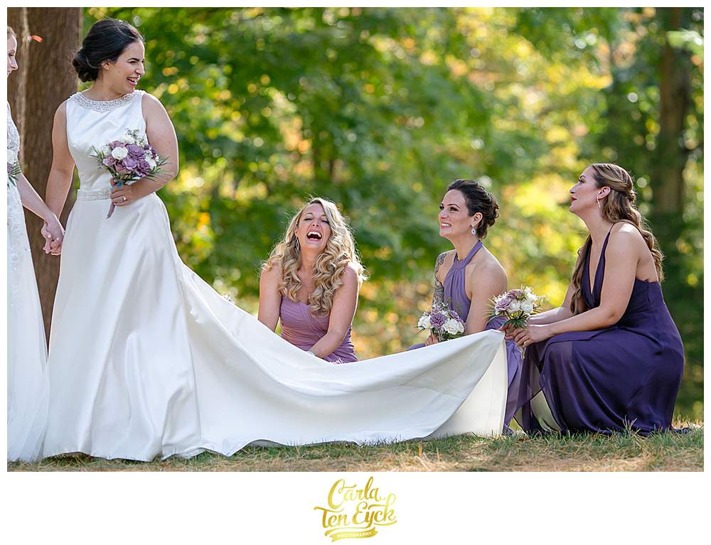 Two brides laugh with their wedding party during their wedding at The Wadsworth Mansion at Long Hill, Middletown CT