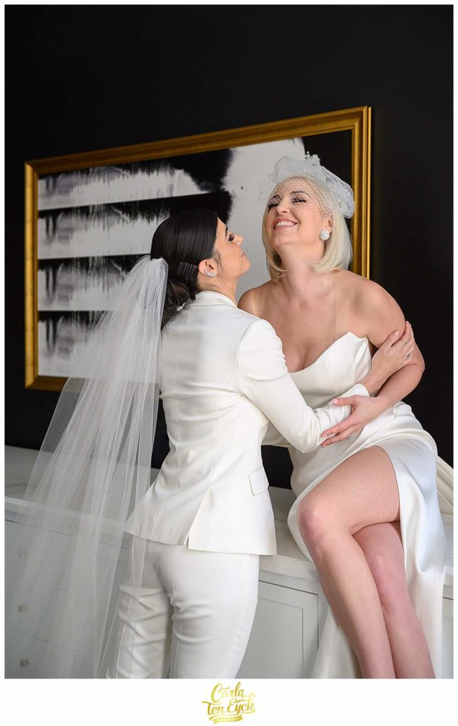 Two brides laugh during photos at their intimate wedding at the Goodwin Hotel in Hartford CT