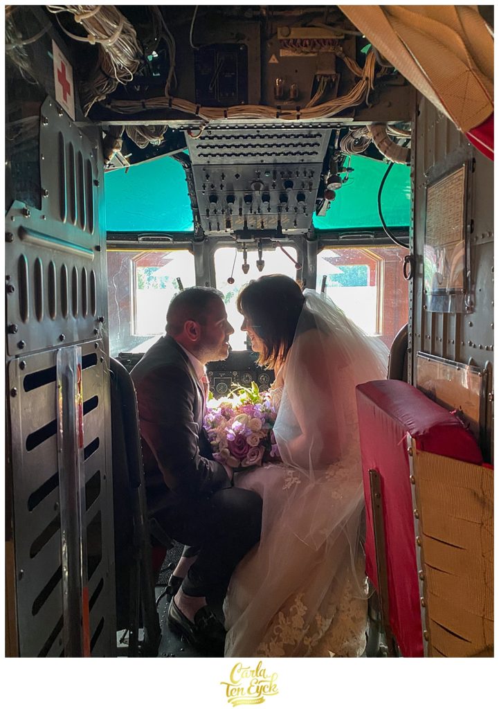 A couple poses in the coast guard helicopter in the helicopter suite at their Winvian wedding in Morris CT