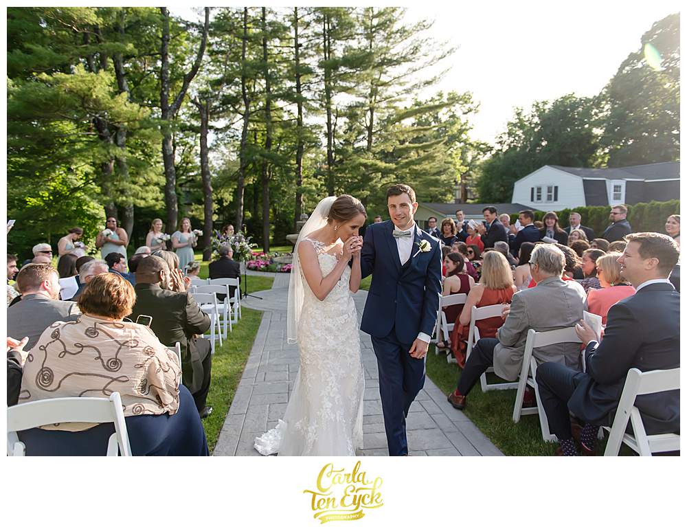A bride kisses her grooms hand at their Fox Hill Inn Wedding in Brookfield CT