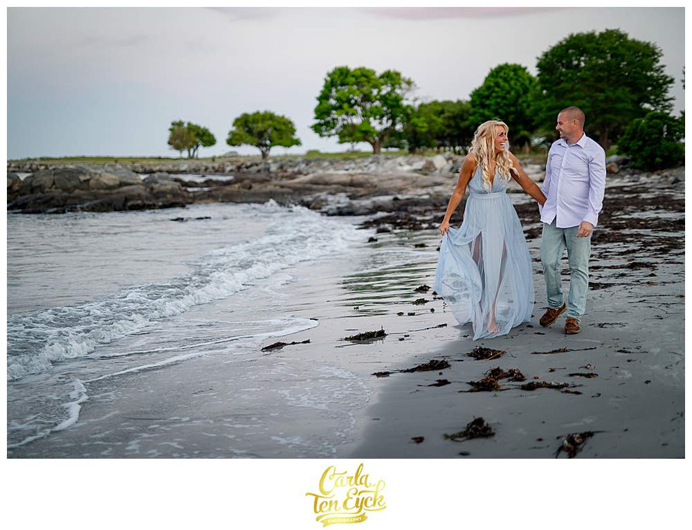 A couple walks along the beach at Great Island Common during their Portsmouth New Hampshire engagement session