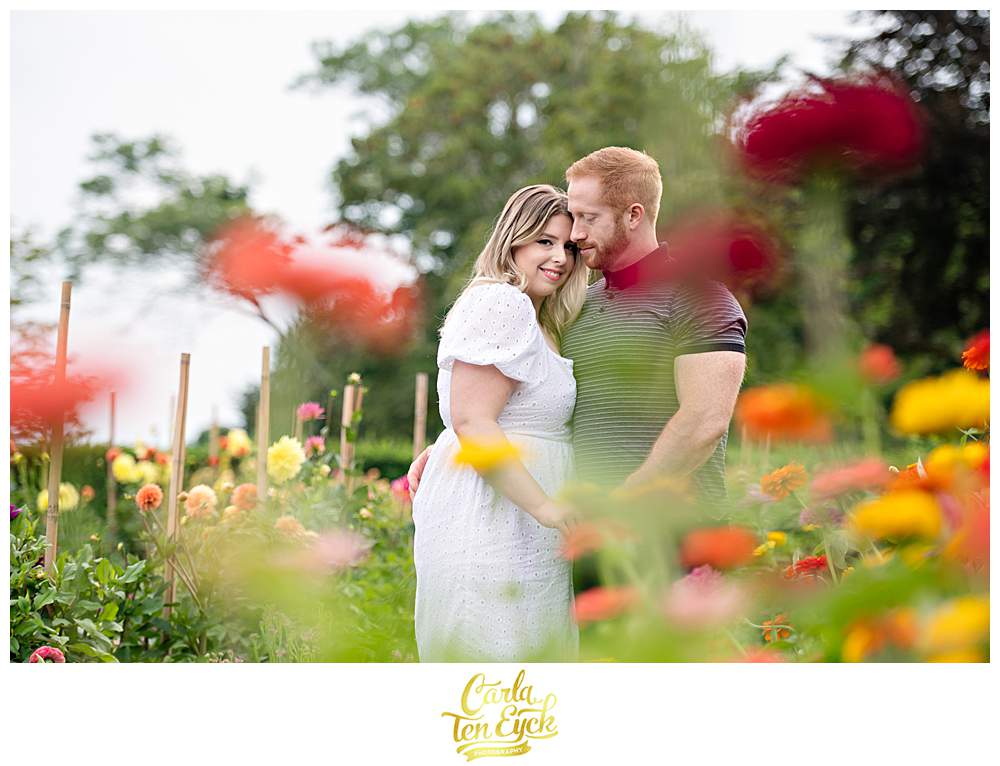 A couple poses in the zinnia garden at Harkness Park in Waterford CT during their engagement session