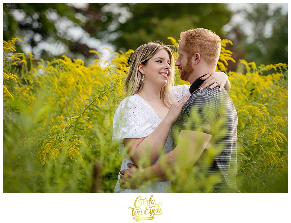 A couple snuggles in the goldenrod during their Harkness Park engagement session in Waterford CT