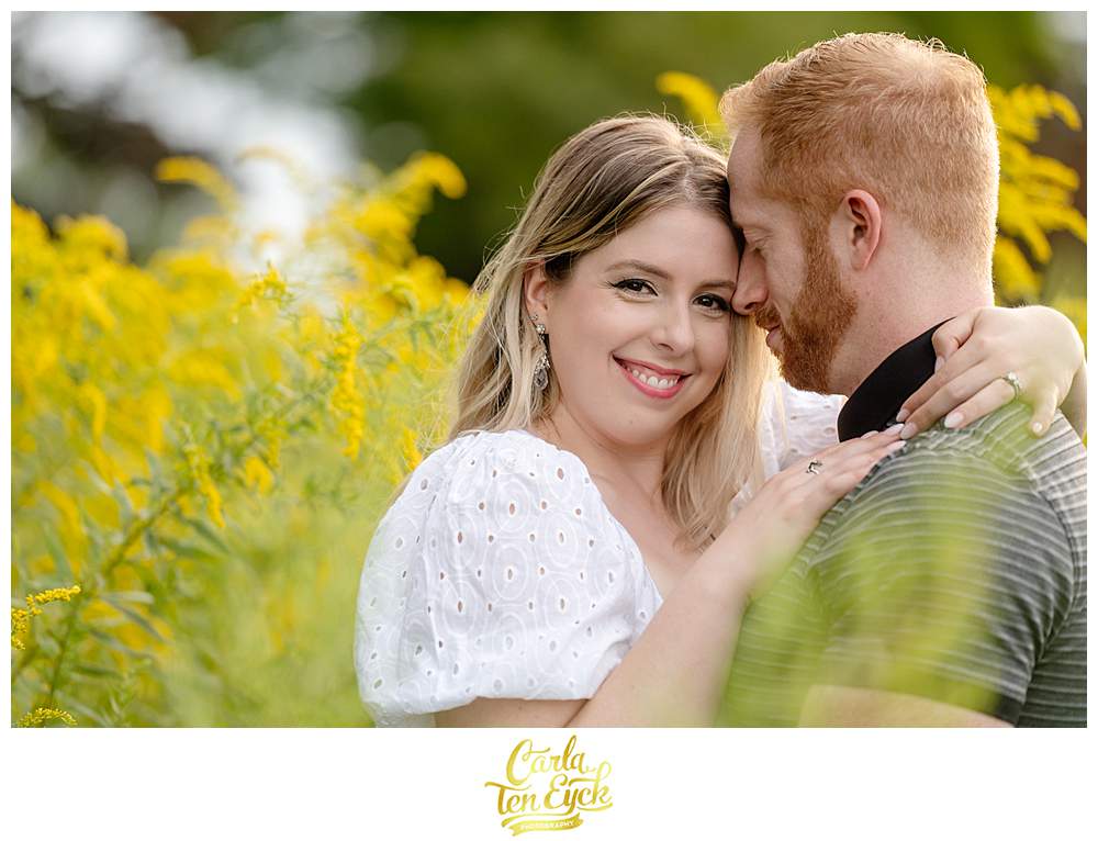 A couple kisses in the goldenrod at Harkness Park in Waterford CT during their engagement session