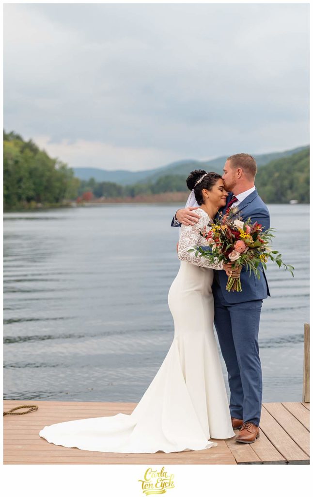 A groom kisses his bride during their summer camp wedding at Camp Lenox in Otis MA