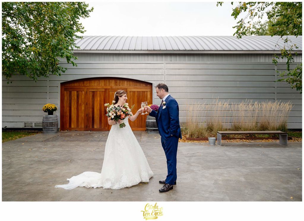 A bride and groom toast after their autumn Saltwater Farm vineyard wedding in Stonington CT