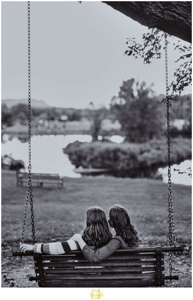 Two brides to be swing on the Smith College campus in Northampton MA during their engagement session.