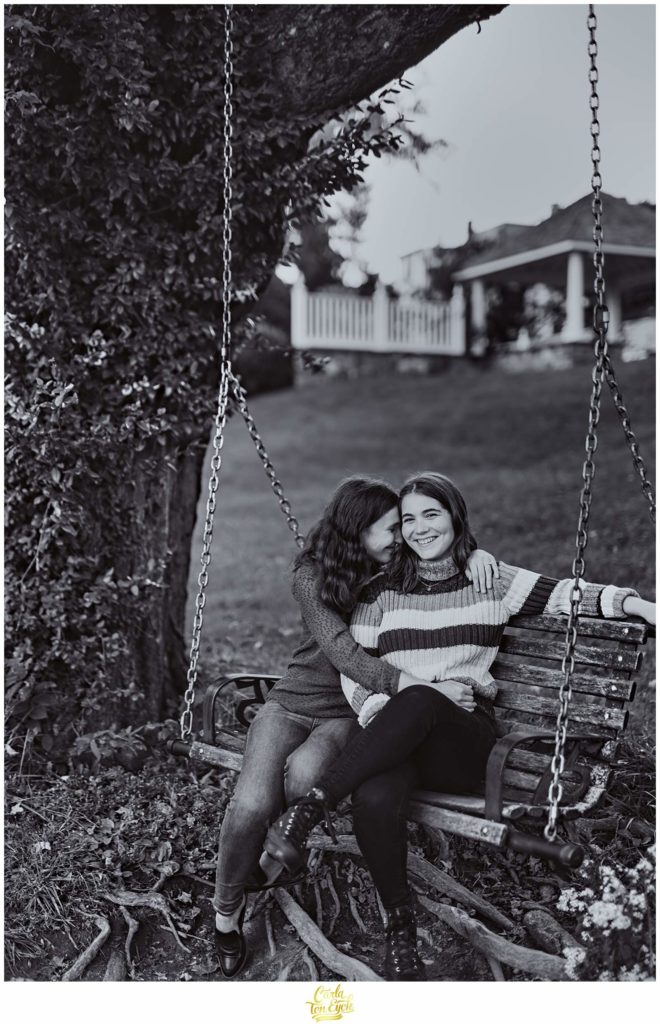 Two brides to be swing on the campus of Smith College in Northampton MA during their engagement session.