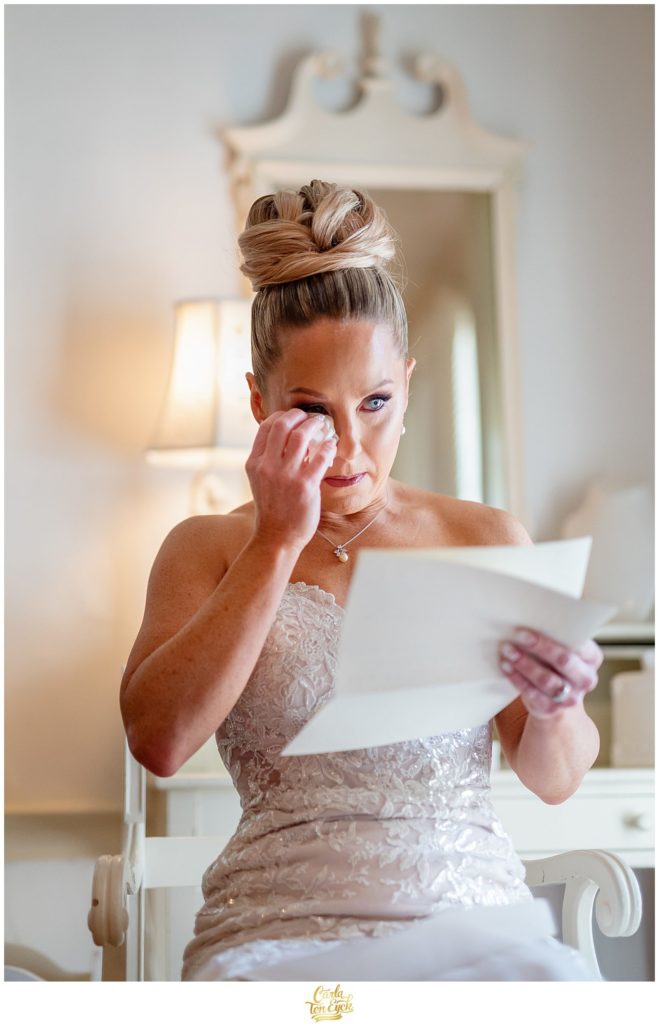 A bride reads a letter from her soon to be husband before their winter Lord Thompson Manor wedding in Thompson CT