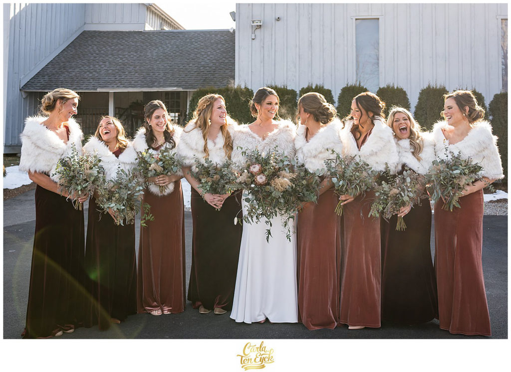 A bride and her bridesmaids laugh at their wedding at The Barns at Wesleyan Hills in Middletown CT