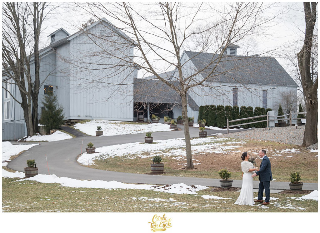 A bride and groom pose for photos in the winter at their wedding at The Barns at Wesleyan Hills in Middletown CT