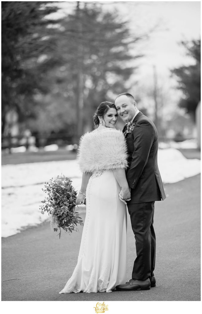 A bride and groom pose for photos in the winter at their wedding at The Barns at Wesleyan Hills in Middletown CT