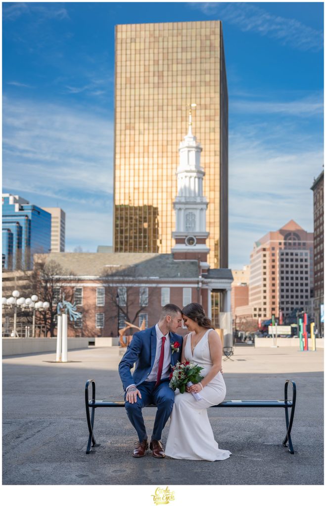 A couple snuggles for wedding photos during their Hartford City Hall Spring elopement, in Hartford CT