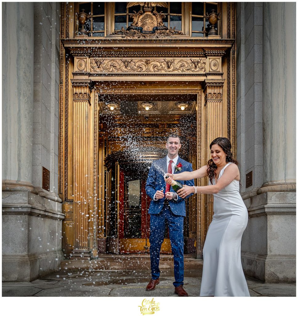 A bride and groom pop champagne at their Hartford City Hall Spring elopement, in Hartford CT