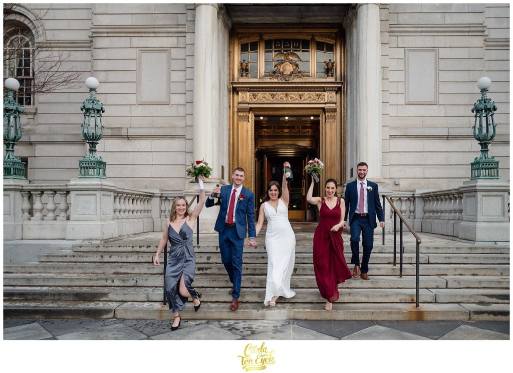A couple celebrates with their wedding party at their Hartford City Hall Spring elopement, in Hartford CT
