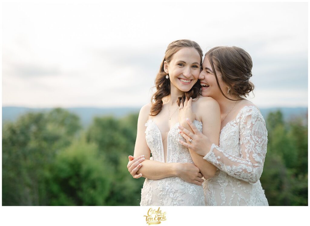Two brides cuddle at their wedding at The Log Cabin in Holyoke MA